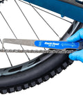 Hand using No Guesswork Bicycle Chain Wear Checker Pro Grade Gauge For Half Inch Pitch Chains on bike chain
