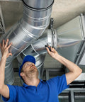 Technician adjusts duct clamp 6 inch V shape 304 stainless steel pipe clamp for ventilation ducting, HVAC system installation
