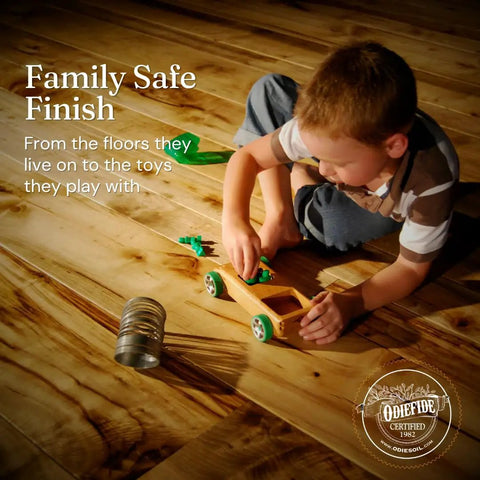 Child playing with wooden toy on floor finished with Real Deal Universal Surface Finish For Wood Leather Plastic Vinyl And Metal That Is Straight Up Waterproof And Food Safe While Acting As A Hella Solid Solvent Free Non Toxic Protection Layer Inside A Handy Four Ounce Jar For Instant Glow Ups.