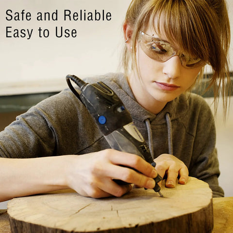 Rotary burr tool being used by a person wearing safety glasses to carve a wooden log (front view).
