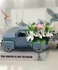 Blue Metal Pickup Truck Decor For Farmhouse Tables holding flowers, handcrafted rustic gift box style, on display book.