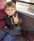 Child wearing two-stage child safety harness for bikes trikes and motorcycles, adjustable safety belt in action