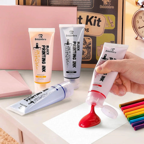 Linoleum Block Printmaking Kit With Four Color Ink Linocut Tools Brayer And Baren Ink Plate Transfer Papers Sharpener Stone And Rubber Stamp Craft Set For Kids DIY Gift showing tubes of colored ink being used.