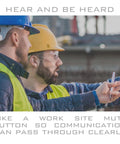 Two construction workers discussing plans while wearing protective gear on site.
