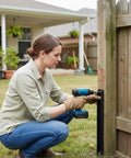 Person using drill to install Two Piece Fence Post Repair Kit With Heavy Duty 11 Gauge Steel Anchor Stakes for Broken Wood Posts.