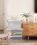 Big Boss 90 Quart Clear Plastic Storage Bins 8 Pack With Snap On Lids stacked with clothes in a cozy living room setting.