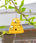 Colorful beehive decor hanging on tree, part of 10 Pack Unfinished Wood Beehive Decor Mini Beehives For DIY Paintable Honeycomb Farmhouse Tiered Tray And Garden Decor 1.8 x 1.9 Inch Small Craft Models For Table Shelf Sitter Party Craft