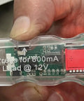 Hand holding Garage Grade Digital Test Light with Load Tester, displaying 7V on screen, 3-30V DC for automotive diagnostics