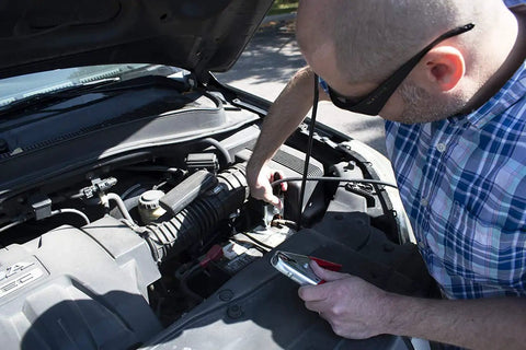 Person using Beefy Heavy Duty Battery Jumper Cables Set With Premium Copper Number 2 Welding Cable 12 Foot Length 500 Amp Clamps On Both Ends Red And Black Vehicle Jump Cables For Quick Starts And Emergency Power to jump-start a car engine