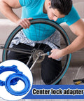 Person using Lightweight Aluminum Center Lock Tool Adapter For Bicycles Disc Brakes Simple Rotor Installation Or Removal For Road And Mountain Bikes Ideal For Travel Camping Outdoor Sports Backpacking And Everyday Maintenance on bike wheel