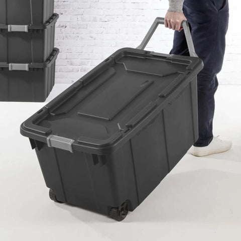 Person rolling Beefy 40 Gallon Storage Bin On Wheels With Locking Lid Resin Plastic Toolbox For Garage, deep gray