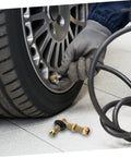 Mechanic checking tire pressure with Beefed Up Off Road Ball Joint Kit For ATVs With Adjustable Suspension on floor nearby.
