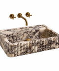 Calacatta Viola Marble Apron Sink, Hand-Carved Fluted Bathroom Washbasin with gold faucet, rectangular natural stone.