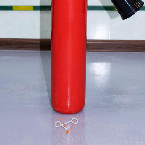 30 Pack Fire Extinguisher Replacement Seals With Tamper Proof Security Pins next to a red extinguisher on a smooth surface.