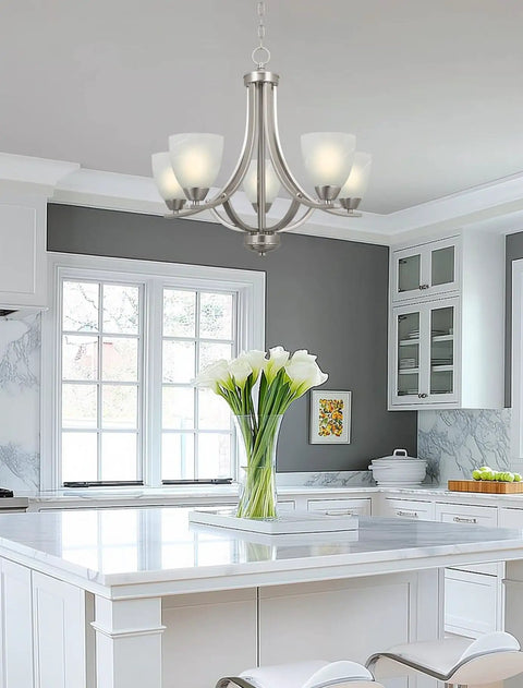Farmhouse 24 Inch Five Light Chandelier With Clear Glass Shades in modern kitchen with white cabinetry.