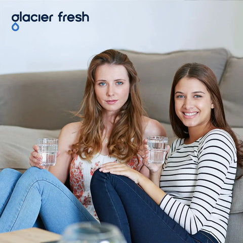 Two women sitting on a couch holding glasses of water, demonstrating clean tasting water from Replacement Faucet Filter For Brita On Tap Water System 36311 Tubular Element Filter Pack Of 2 Easy Install Compatible With FR200 FF100 And All Brita Tap Filters Long Lasting Performance For Clean Tasting Water And Easy Replacement.