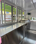 Interior view of a custom mobile coffee and pastry trailer featuring stainless steel counters, fridge, and sink for quick street vending.