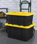 Six Pack Heavy Duty Stackable Industrial Totes Top Shelf Plastic Storage Bins With Secure Snap Lids Rock Solid Build For Garage Workshop And Warehouse Organization Black And Yellow stacked with rolling cart in garage setting.
