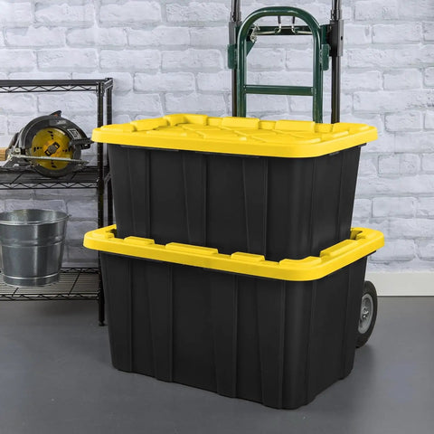 Six Pack Heavy Duty Stackable Industrial Totes Top Shelf Plastic Storage Bins With Secure Snap Lids Rock Solid Build For Garage Workshop And Warehouse Organization Black And Yellow stacked with rolling cart in garage setting.