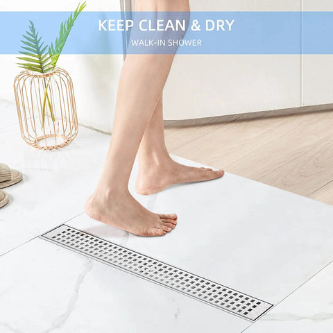 Person stepping on 60 Inch Linear Shower Drain In Brushed Nickel V Shaped Large Displacement 304 Stainless Steel Rectangular Floor Drain.