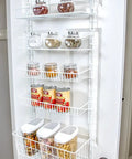 Over The Door Pantry Organizer Rack With Six Adjustable Shelves, white steel storage unit holding jars and cans on open door