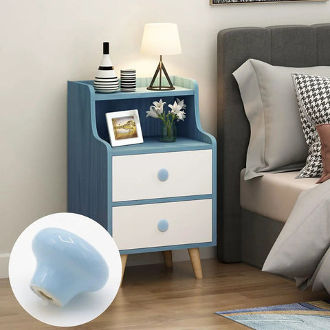 Top Shelf 10 Pack Ceramic Cabinet Knobs And Drawer Pulls In Sweet Sky Blue Featuring Hella Durable 32mm Round Design With Complete Mounting Hardware For A Fresh Kitchen Bedroom Makeover on a bedside table.