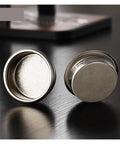 Premium Titanium Portafilter Basket 58.5mm Holds 18 To 20 Grams with shiny surface and perforated bottom for brewing.