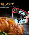 Digital thermometer in chicken showing 87.5°C with "Hold" function visible on display, highlighting use during cooking.