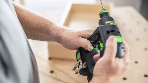 Person using Compact Cordless Drill Driver CXS 18 HPC 18V with 4.0 Ah Battery in workshop setting