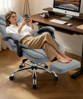 Woman relaxing on Ergonomic 400lbs Capacity Reclining Office Chair With Footrest And Back Support High Back Wide Seat Napping Recliner PU Leather Big Tall Boss Level Executive Manager Chair For Home Office Grey at desk