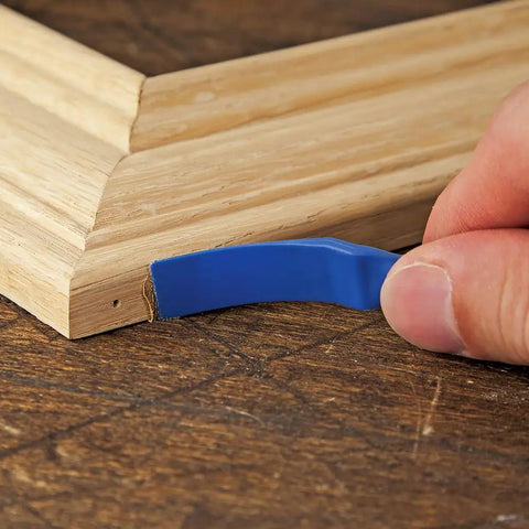 Hand using Reusable Glue Spreader Paddles Set Of Three With Four Tip Widths One Eighth To One Half Inch For Precise Glue Application Reaching Tight Corners Handy Grip And Easy To Clean Glue Tool For Grooves Dados And More on wood corner