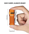 Hand holding Baton4 Rechargeable EDC Flashlight With 1300 Lumens, bright orange, pocket-sized, showing dimensions 2.48in by 0.83in.