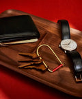 Wilson Brass Keyring With 2 Inch Carabiner Clip on tray with watch, wallet, and keys