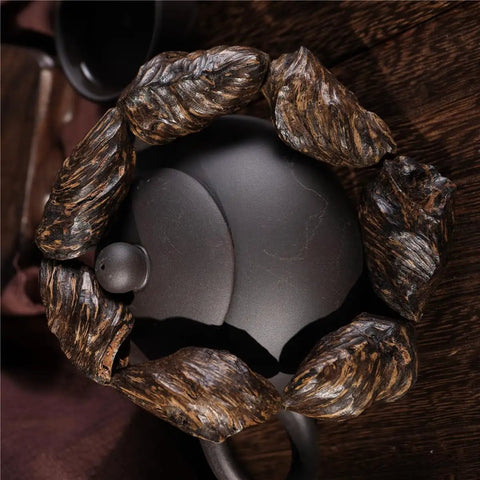 Vietnam Nha Trang Agarwood Unisex Jewelry Burl Scarred Black Oil Aged Bracelet with Adjustable Elastic Band on dark surface