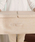 Collapsible Linen Fabric Storage Bin For Clothes Shoes And Toys Nifty Foldable Home Basket being held, beige color, compact size.