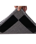 Hand lifting rug corner showing 16 Pack Anti Slip Rug Tape Double Sided Carpet Grip For Hardwood Floors And Tiles Prevents Slipping Curling And Bunching On Area Rugs No Slip Pad That Stays Put under it.