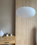 Large White Chinese Paper Ceiling Lamp Shade And Oval Pendant Light Cover With Vintage Round Chandelier Lantern Design in a modern room.