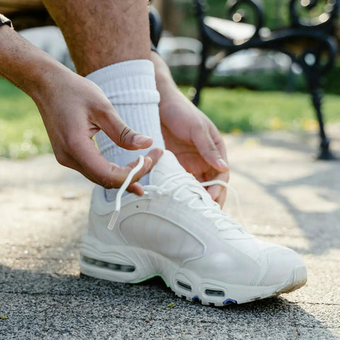 Upgrade Your Daily Drip With Top Tier Metal Alloy Shoe Lace Tips Built To Outlast Worn Aglets Quick Fully Adjustable Cord Ends Fit Any Pair Of Modern Trainers Perfectly on white sneaker with laces being tied.