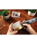Person using Ultra Compact Four Volt Cordless Rotary Tool Featuring Variable Speed And No Sweat Accessory Swaps for crafting.