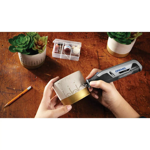 Person using Ultra Compact Four Volt Cordless Rotary Tool Featuring Variable Speed And No Sweat Accessory Swaps for crafting.