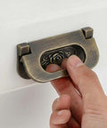 Hand using Antique Bronze Rose Flush Pull Handles for drawers and cabinets, hidden flush mount design, close-up view, 2 pack