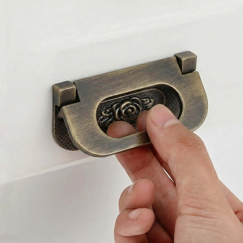 Hand using Antique Bronze Rose Flush Pull Handles for drawers and cabinets, hidden flush mount design, close-up view, 2 pack