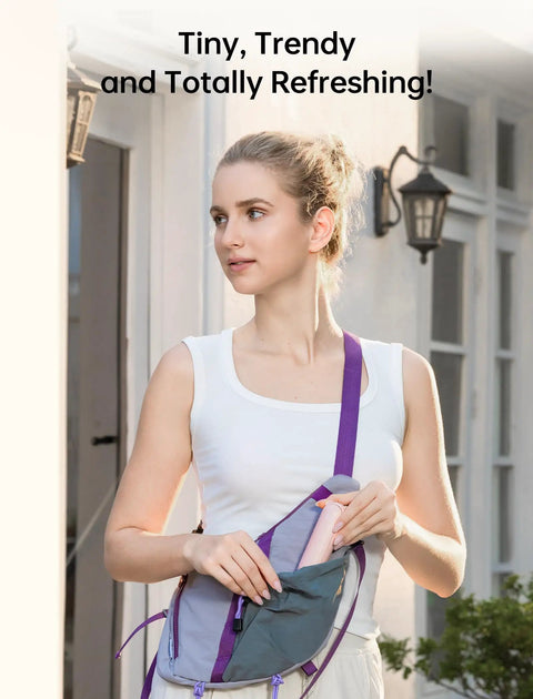 Woman inserting 3 In 1 Pocket Handheld Mini Fan With Built In Power Bank And Flashlight USB Rechargeable into a sling bag