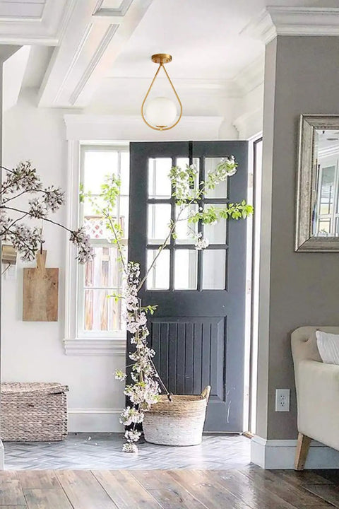 Industrial Mid Century Modern Brass Semi Flush Mount Ceiling Light With Opal Milk Glass Globe Fixture in a bright living area