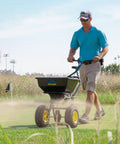 Man using Spyker All Season Spreader Kit Ergo Pro 50 Pound Broadcast Spreader on lawn