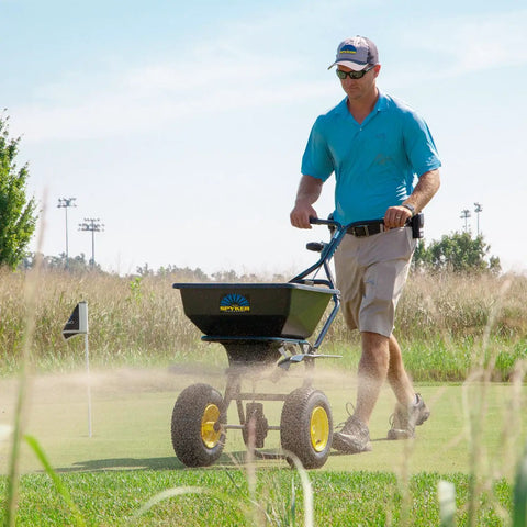 Man using Spyker All Season Spreader Kit Ergo Pro 50 Pound Broadcast Spreader on lawn