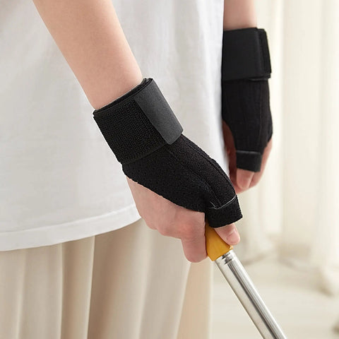 Person wearing Reversible Thumb And Wrist Stabilizer Splint Brace For Trigger Finger Pain Relief, holding a tool, lightweight black.
