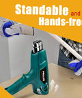 Dual Temp Heat Gun Kit With 752F To 1112F Hot Air Beast For Crafts 4 Nozzles Shrink Wrap Tubing Paint Removal Lightweight Safe With Stand And Overheat Protection being used on a workbench with gloves and tools nearby.