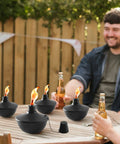 4 Pack Metal Tabletop Torches 22oz Citronella Scented Outdoor Torches For Patio Deck And Garden on wooden table with people