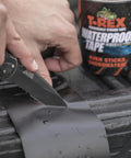 Heavy Duty Waterproof Repair Tape For Wet And Rough Surfaces Including Underwater Leaks Patching Up Like A Pro Indoors Or Outdoors 2 Inch By 5 Foot Black One Roll being applied and cut on a surface